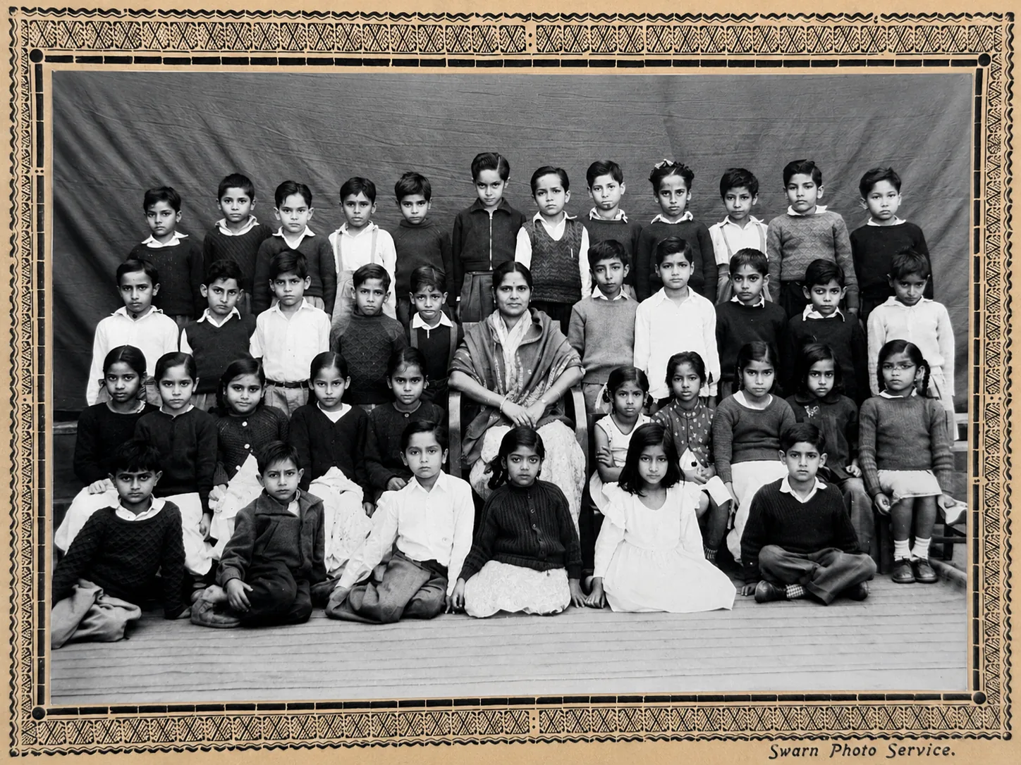 A Class III group photograph from 1962-63, the children in four rows with their teacher seated at the centre, in its original printed mount signed Swarn Photo Service