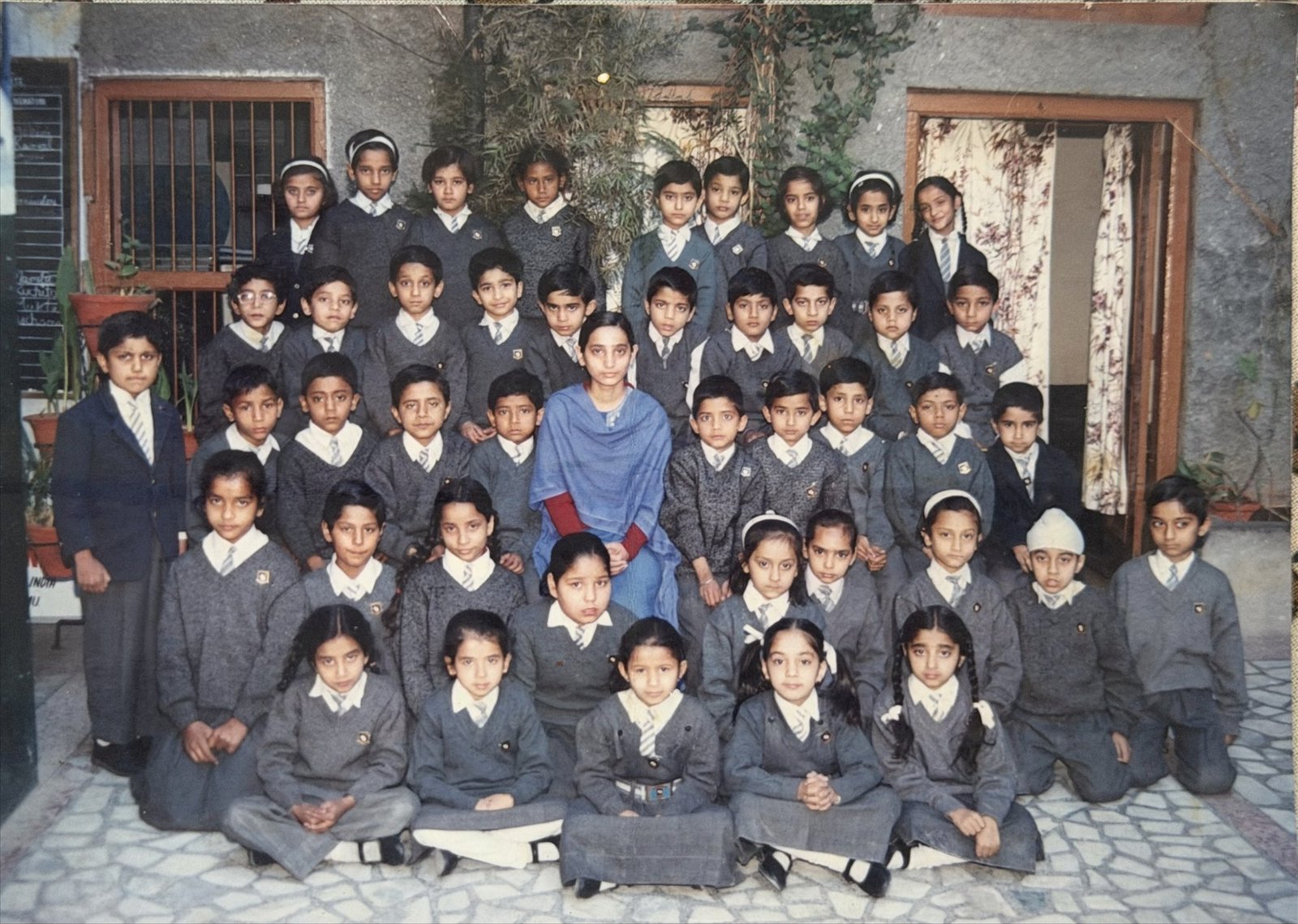 A 1990s class of Oriental Academy with their teacher, gathered in the courtyard outside the principal's office
