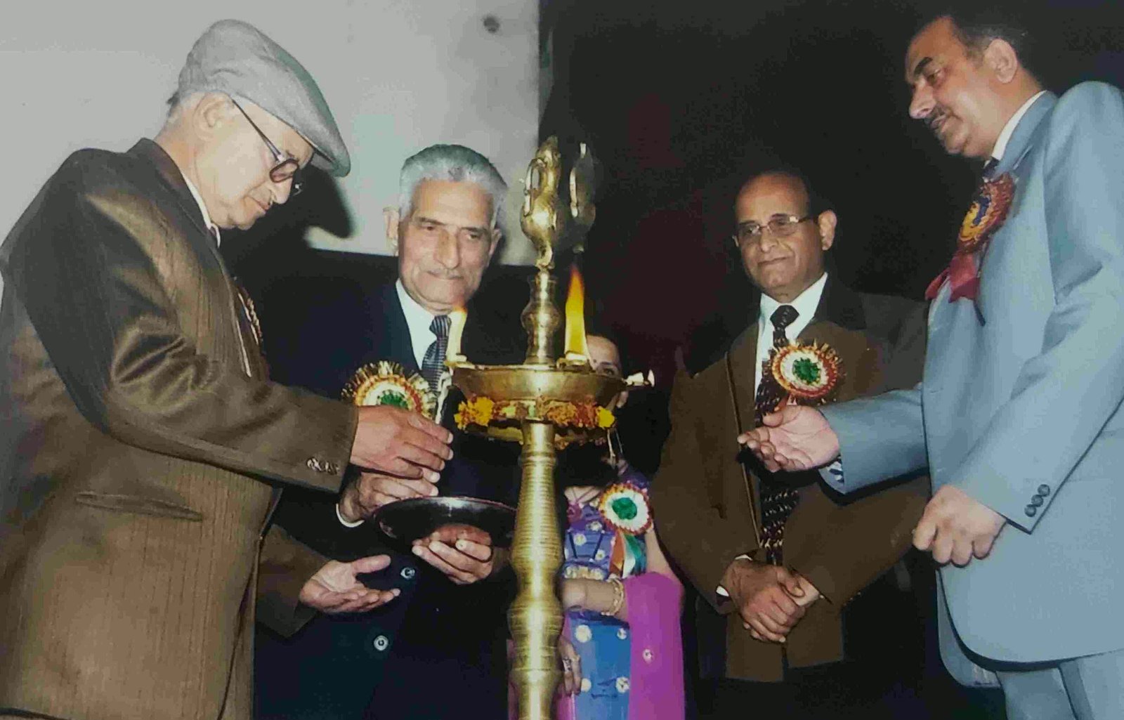 Guests lighting a brass ceremonial lamp to open the annual function