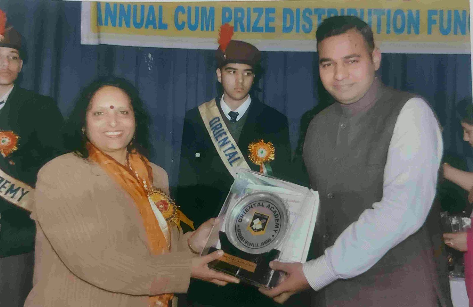 A student wearing an Oriental Academy sash receiving an award at the prize distribution