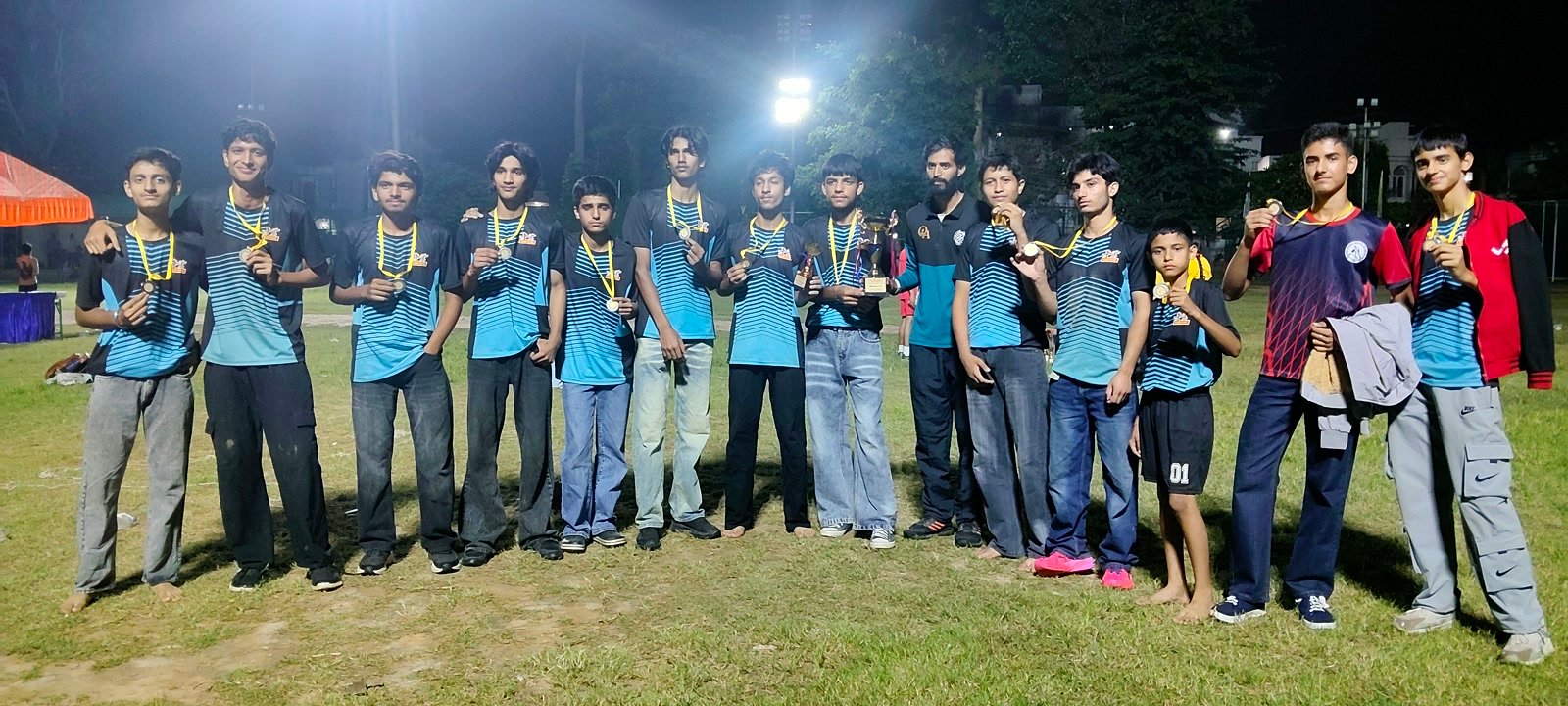 Oriental Academy players wearing their medals under the floodlights