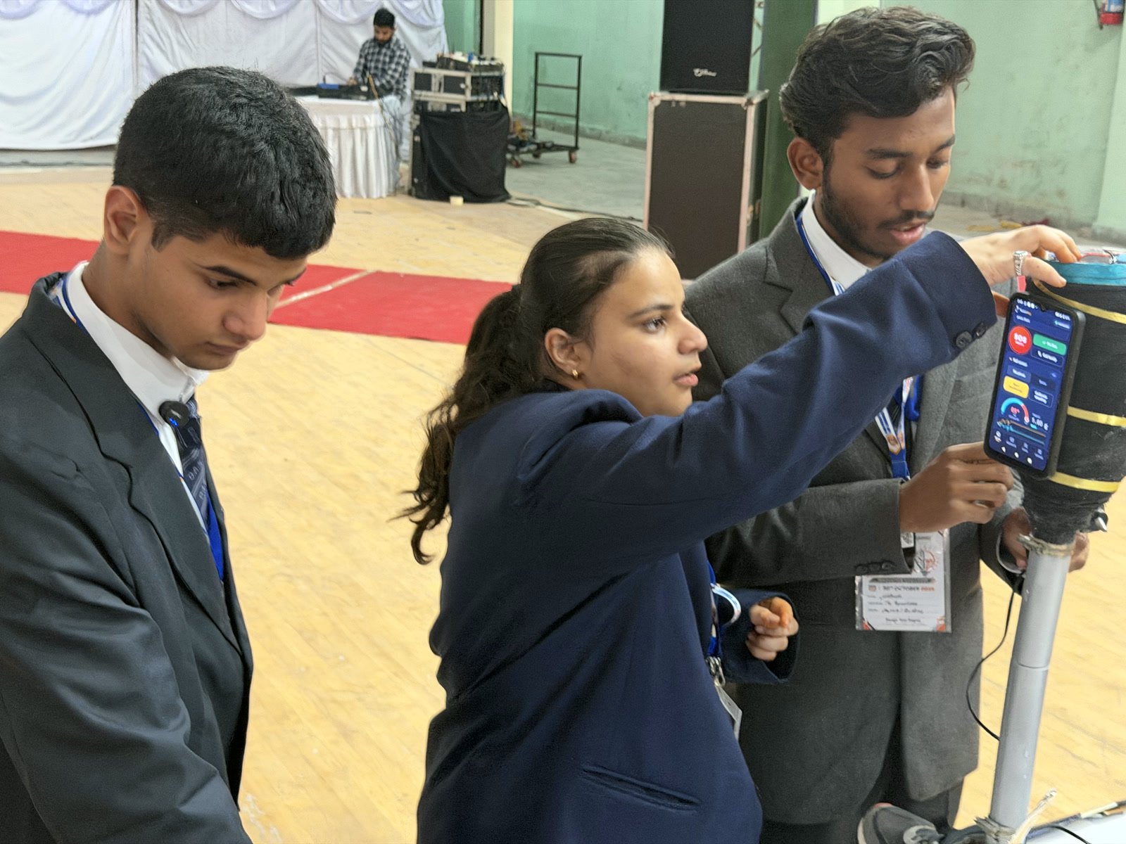 NeuroStep team members with the prosthetic leg and the phone app attached to it
