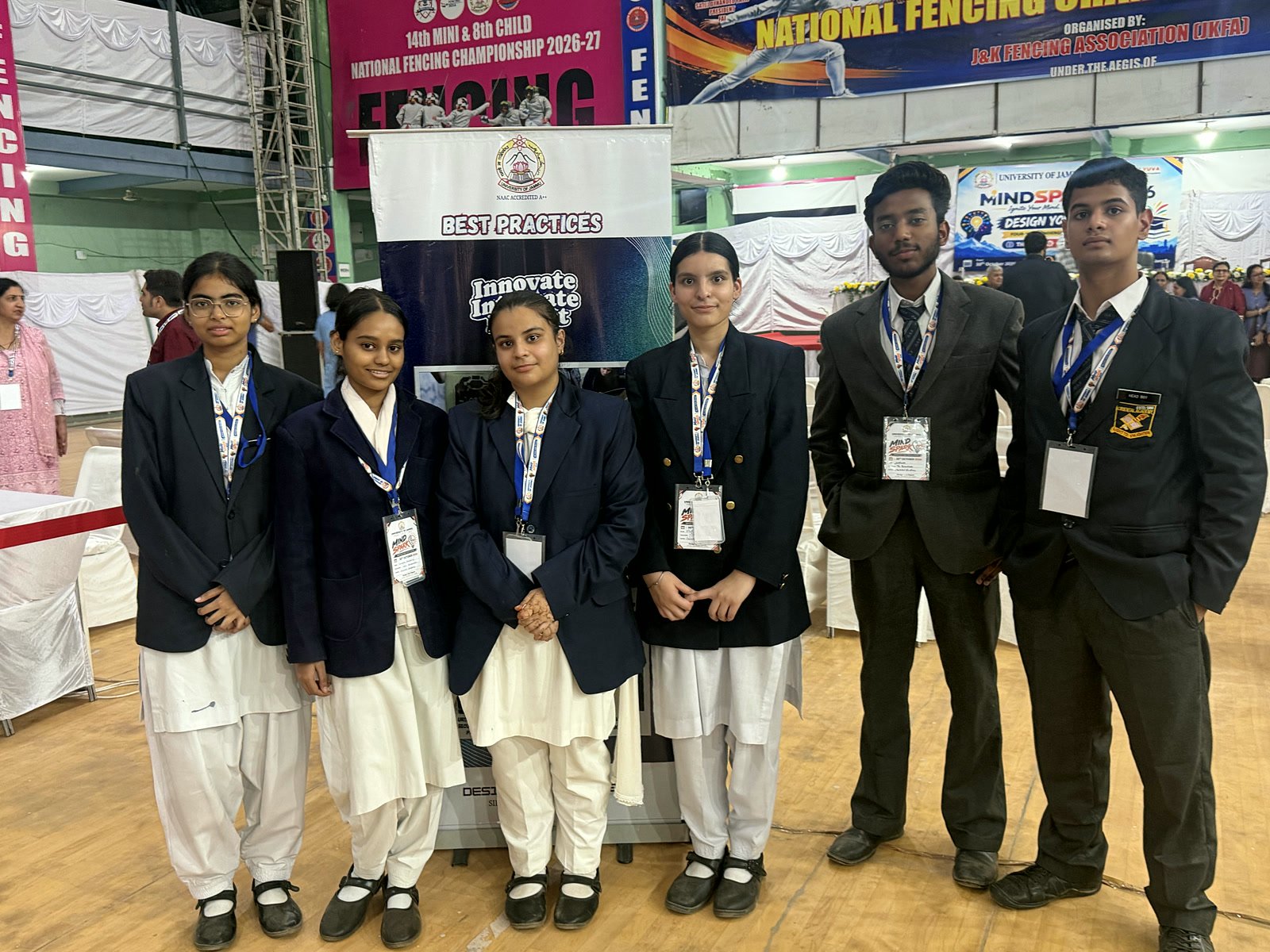 Six Oriental Academy students in school blazers standing together in the Gymnasium Hall at MindSpark-2026, University of Jammu