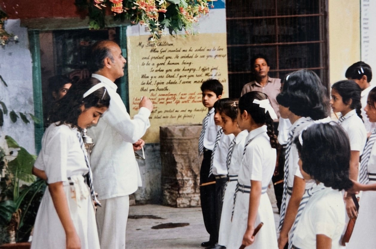 Late Sh. Ved Prakash Chauhan with his students, in front of the hand-painted wall with his words ‘My dear children…’