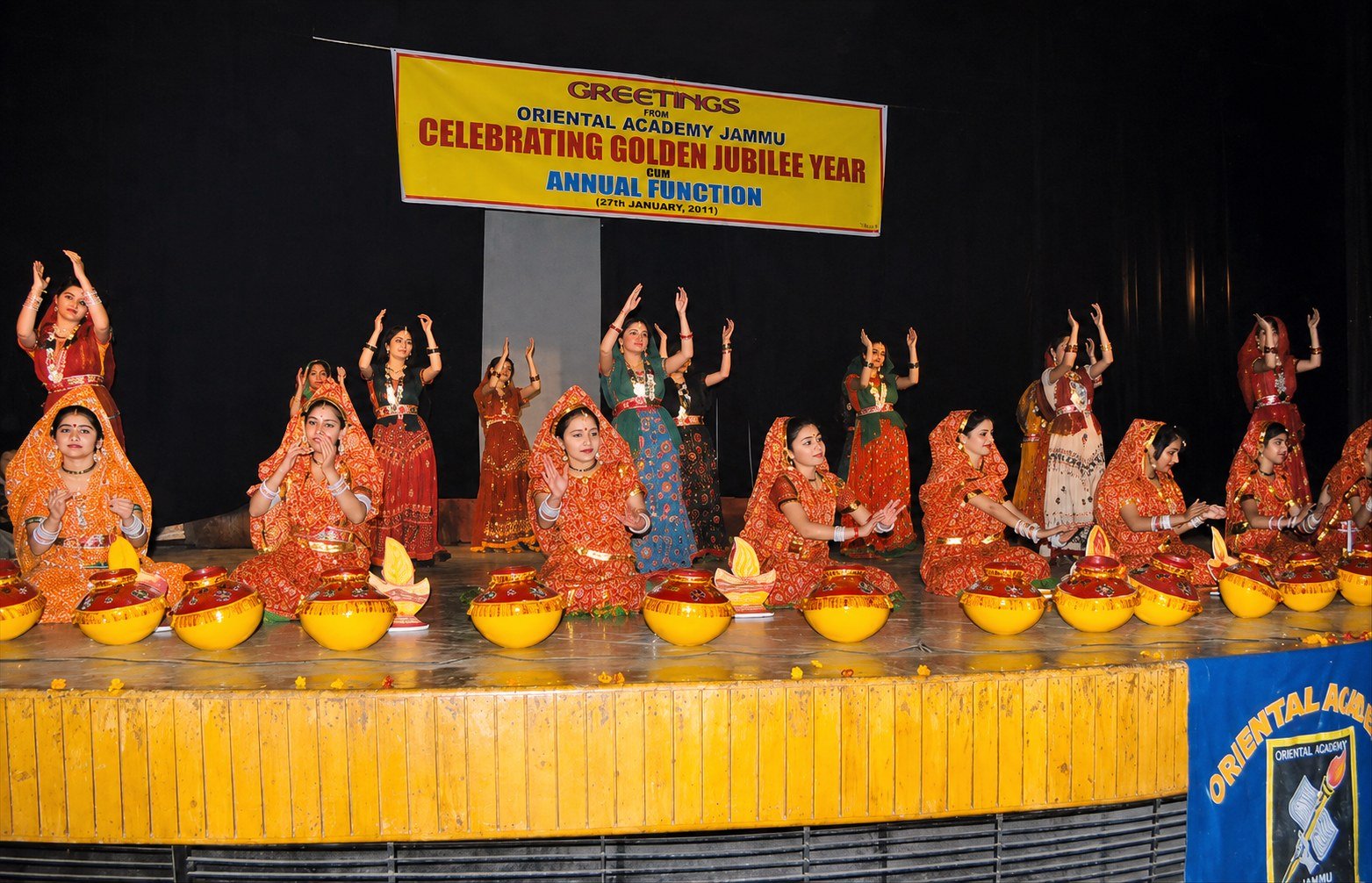Students performing behind rows of decorative diyas at the Golden Jubilee annual function, 2011