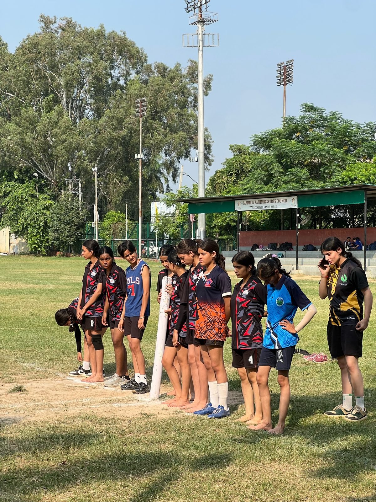 Oriental Academy girls lined up at the touchline at the Jammu and Kashmir Sports Council ground, Green Field, Gandhi Nagar