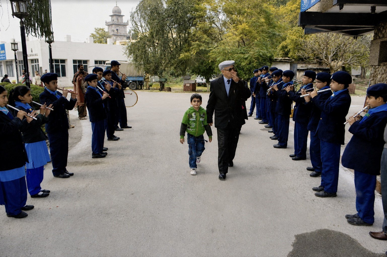 The founder walking in through a guard of honour formed by the school band