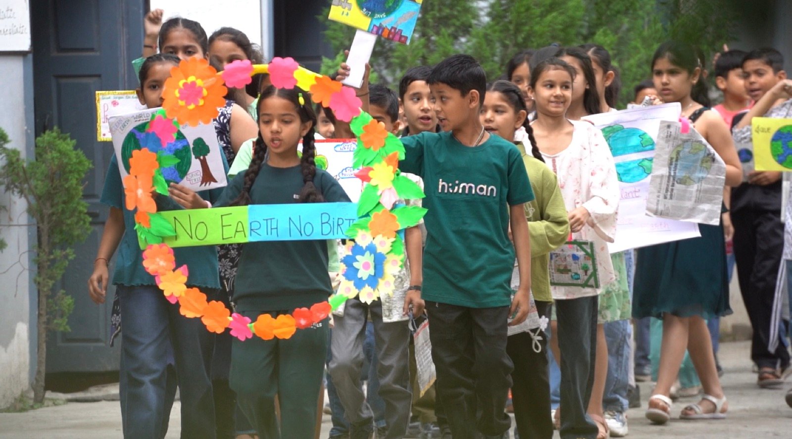 Students marching with handmade placards on Earth Day: 'No Earth, No Birth'