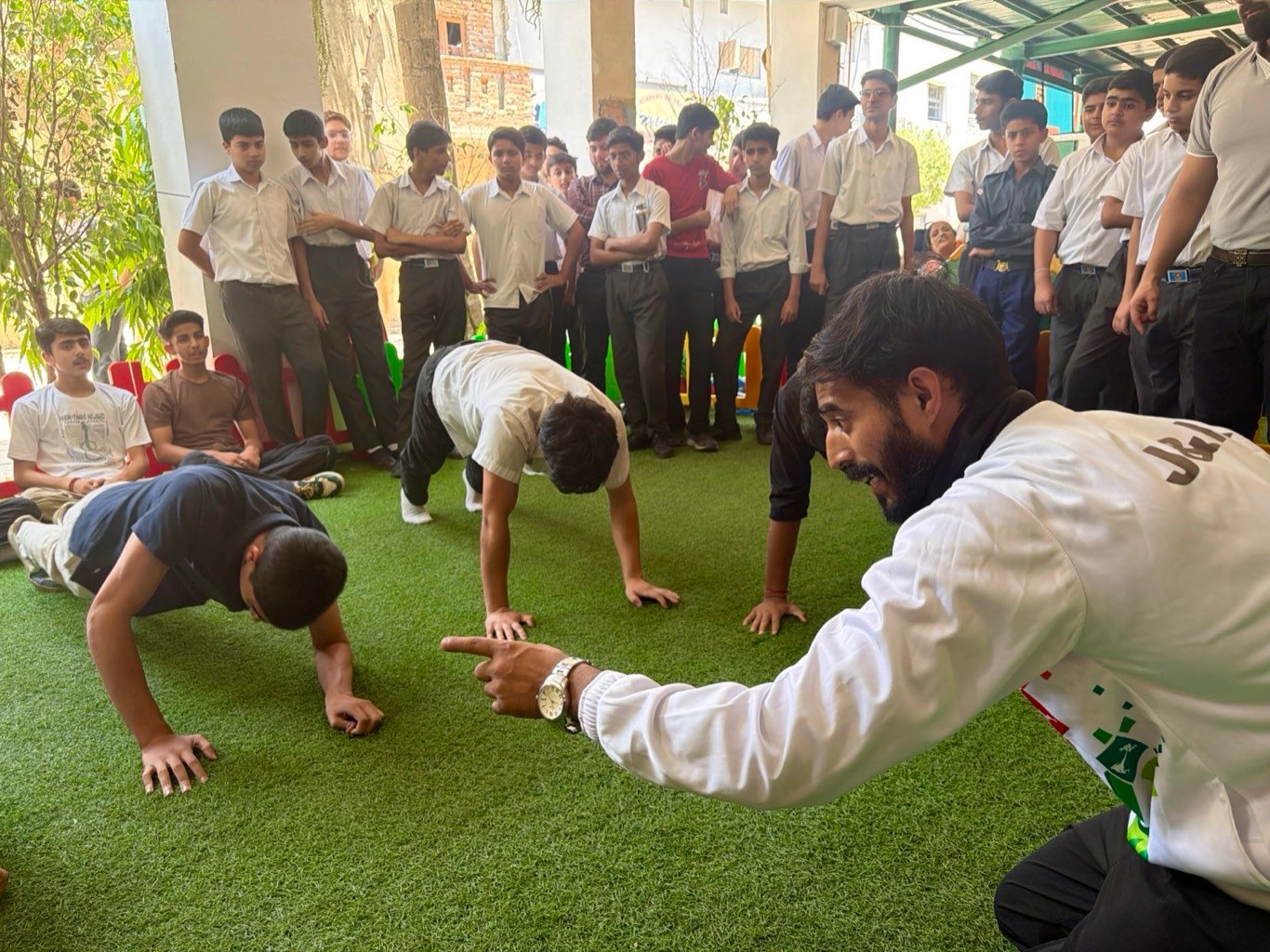 The coach counting push-ups during a sports session on the green turf